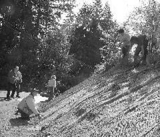 John Hofstrand tightens the erosion blanket while Evan McCauley and Joe Stewart adjust the top. Photo by Dennis Box