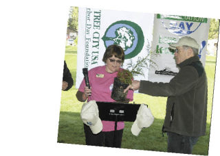 Laurie Carter was presented with a plant from Fred Jacobsen during an Arbor Day ceremony April 18 at Cedarview Park. Carter