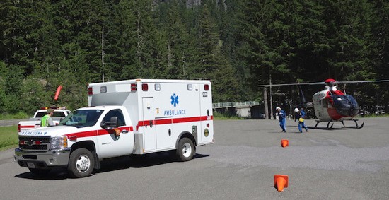 Life flight emergency medical staff meet Mount Rainier rangers and ambulance at the Glacier Bridge parking area