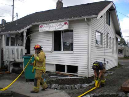 Firefighters clean up following a Friday morning fire at Indulge Cupcakes in Sumner.