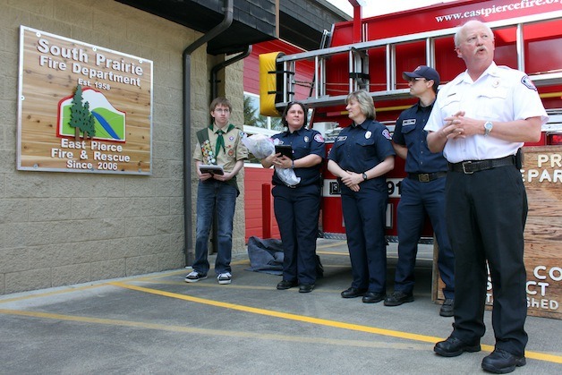 East Pierce Fire and Rescue Fire Chief Jerry E. Thorson commends local Boy Scout Luke Harlor for his efforts in creating a new sign for the South Prairie Fire Station at an unveiling ceremony Saturday. (Pictured from left are Harlor