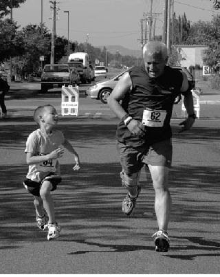 Manuel Martinez races his 6-year-old son  Anthony across the finish line at Saturday  morning’s second annual Enumclaw Street Fair 5K run. His wife Michelle and their 4-year-old daughter Melanie also participated in the event. Approximately 186 runners turned out with Kenny Krotzer