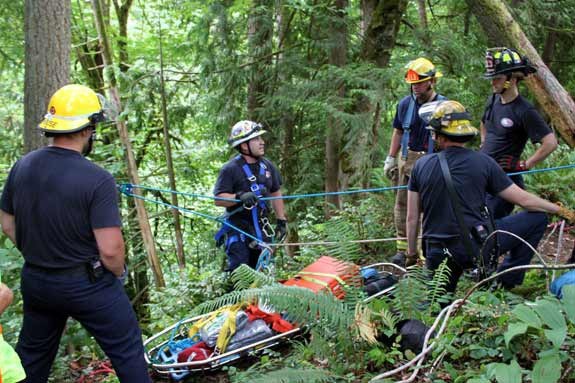 Members of the East Pierce Technical Rescue Team prepare to lift two injured hikers from the base of Victor Falls.