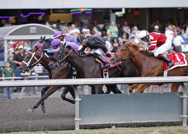 Mike Man's Gold (purple silks) and jockey Javier Matias prevail by a head Saturday in the $50