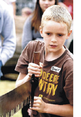 Brad Flanders tries his hand at double  bucking. Flanders won the log rolling and rope climb for 11 to 12 year olds and was second in choker setting.