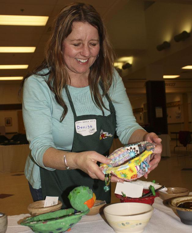 Denise Trivelas checks out a bowl at the Empty Bowl fundraiser Friday