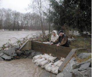 Patricia and Frank Mathis watch the Puyallup River rise Jan. 7 near Rainier Manor in Sumner. More pictures on B6.