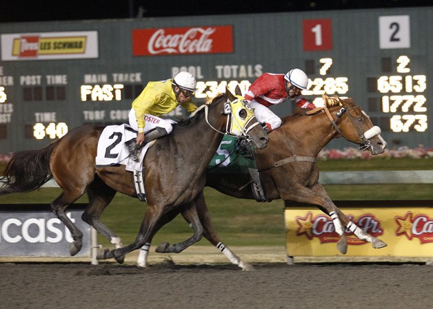 Mr. Mad Max and jockey Debbie Hoonan (red silks) prevail by a head over Ugottabcatty in the feature race for 3-year-olds and up at Emerald Downs. Friday