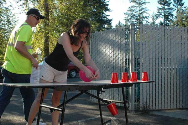 Bonney Lake Court Clerk Helen Williams uses a balloon to blow cups off a table as part of the Welness Committee's Poker Walk Aug. 25.