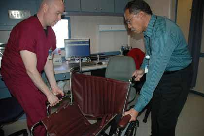 James Paterson and Rich Rosser demonstrate how handy the nonmagnetic wheel chair is in the MRI unit.