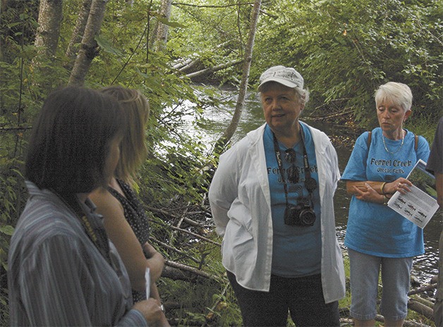 Marian Betzer discusses the Fennel Creek Habitat Team with members of a tour of county restoration projects.