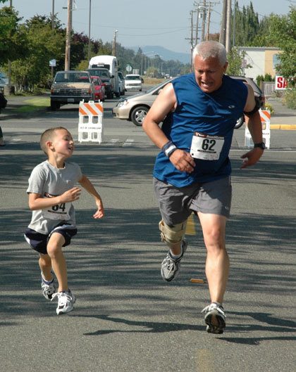 Manuel Martinez races his 6-year-old son Anthony across the finish line at Saturday morning’s second annual Enumclaw Street Fair 5K run. His wife Michelle and their 4-year-old daughter Melanie also participated in the event. Approximately 186 runners turned out with Kenny Krotzer