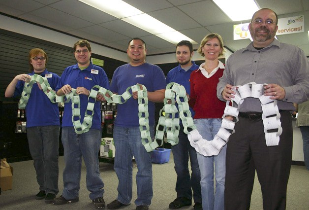 Chuck Bender and his staff at Skynet in Enumclaw hold a chain of Rachel's Challenge links