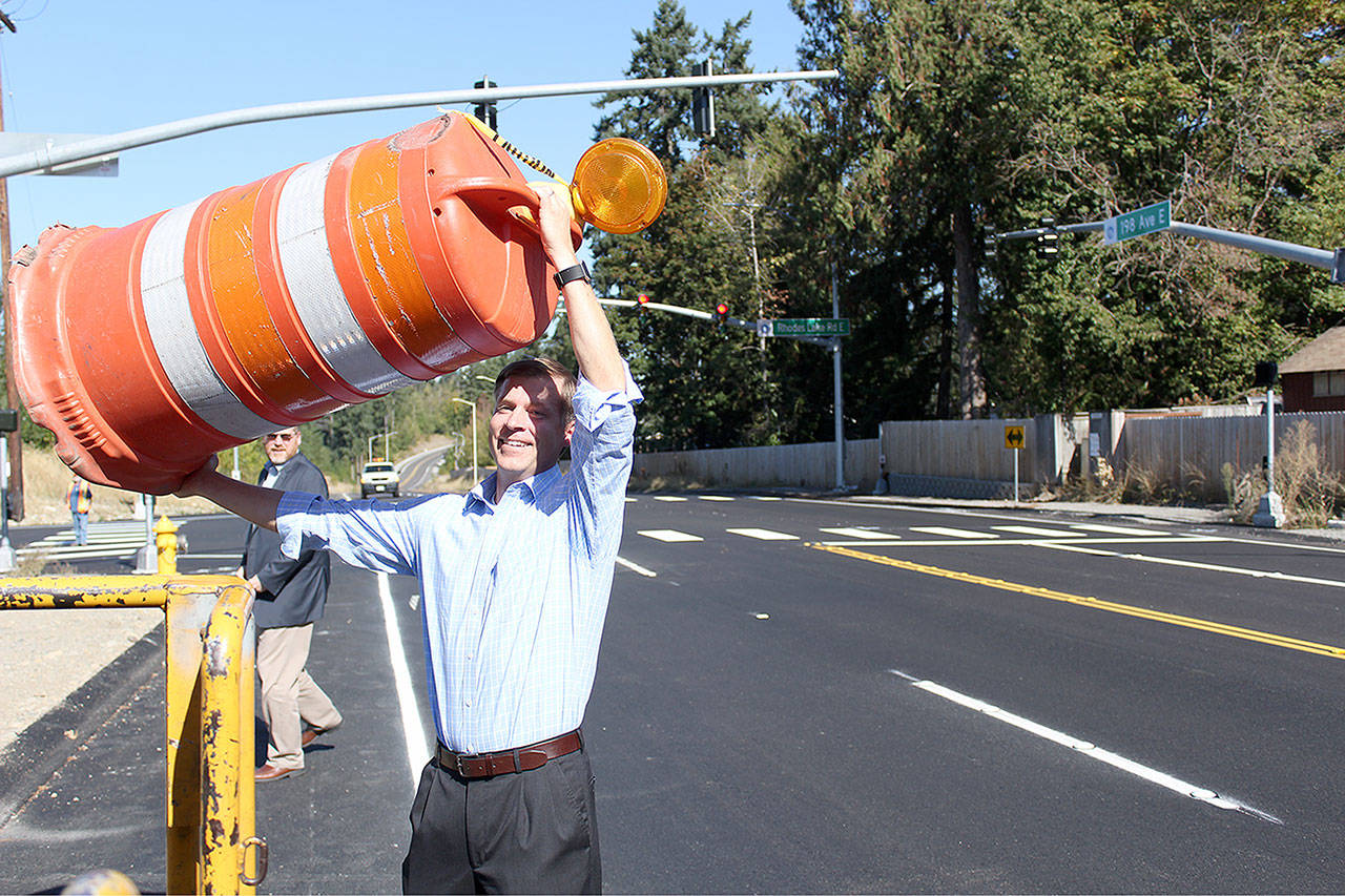 Pierce County councilman Dan Roach removes the “last barrel” to open up the new 198th Avenue and Rhodes Lake Road East intersection. Photo by Ray Still