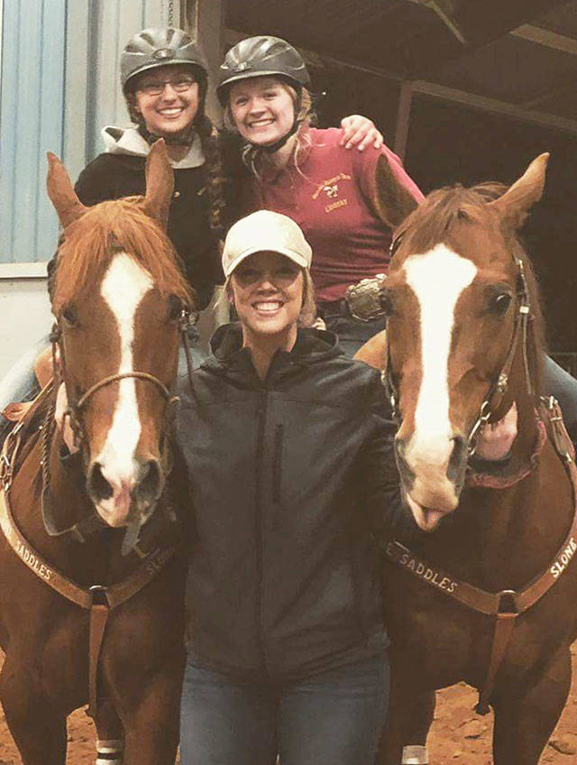 EHS equestrians Lindsay Sogge and Rylee Geddes, on horseback, celebrate breaking the District 3 birangle record. Joining them is gaming coach Elly Burrill. SUBMITTED PHOTO