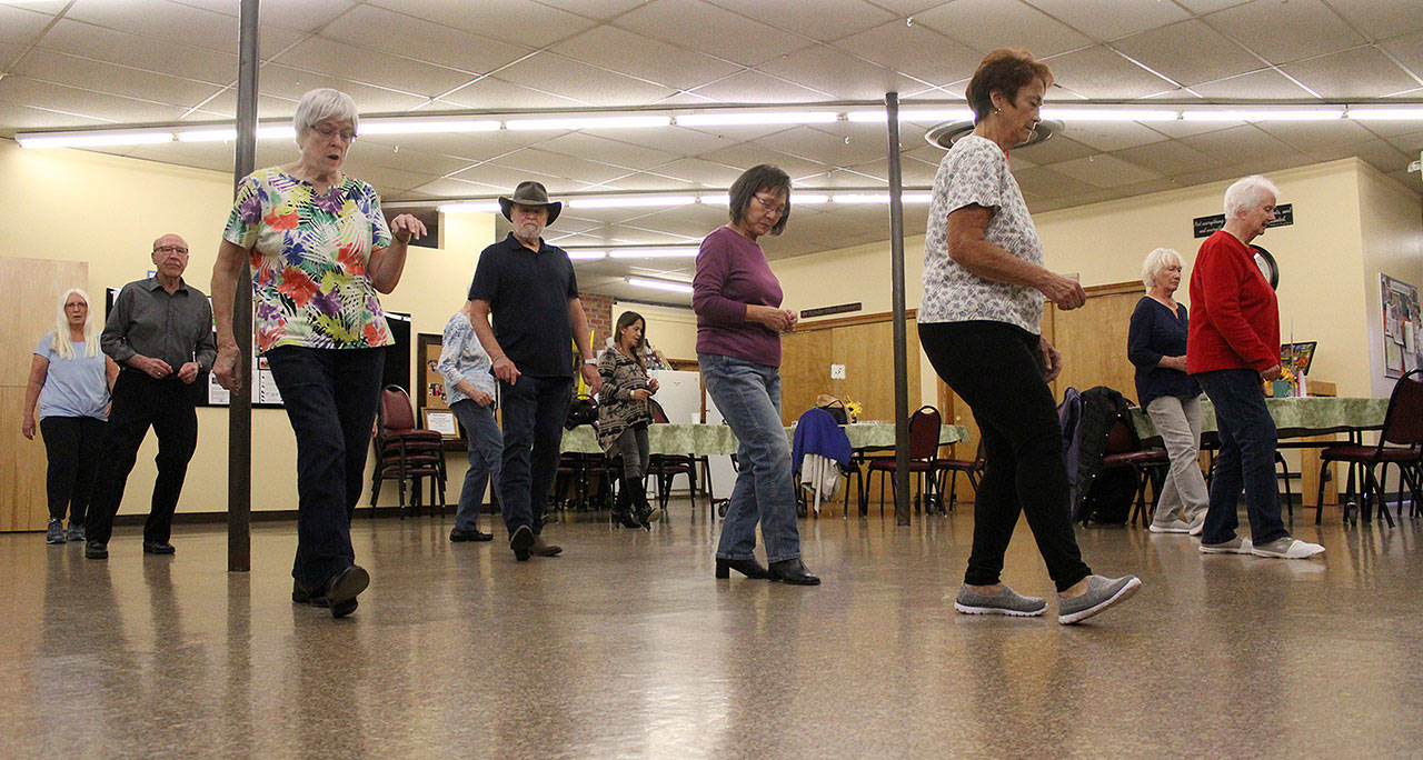 Enumclaw seniors dance along with their new line dance instructor, Sharon Elston, who was just teaching them the Cupid Shuffle. Photo by Ray Miller-Still                                Enumclaw seniors dance along with their new line dance instructor, Sharon Elston, who was just teaching them the Cupid Shuffle. Photo by Ray Miller-Still