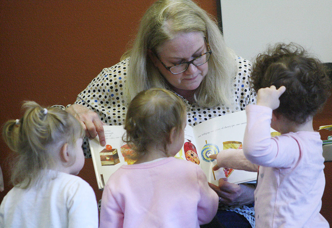 Catherine O’Brien, youth services librarian, keeps kids’ attention during a fall session of Family Story Time at the Bonney Lake library. The hour-long program also included games and interactive play with a colorful parachute. File image by Kevin Hanson