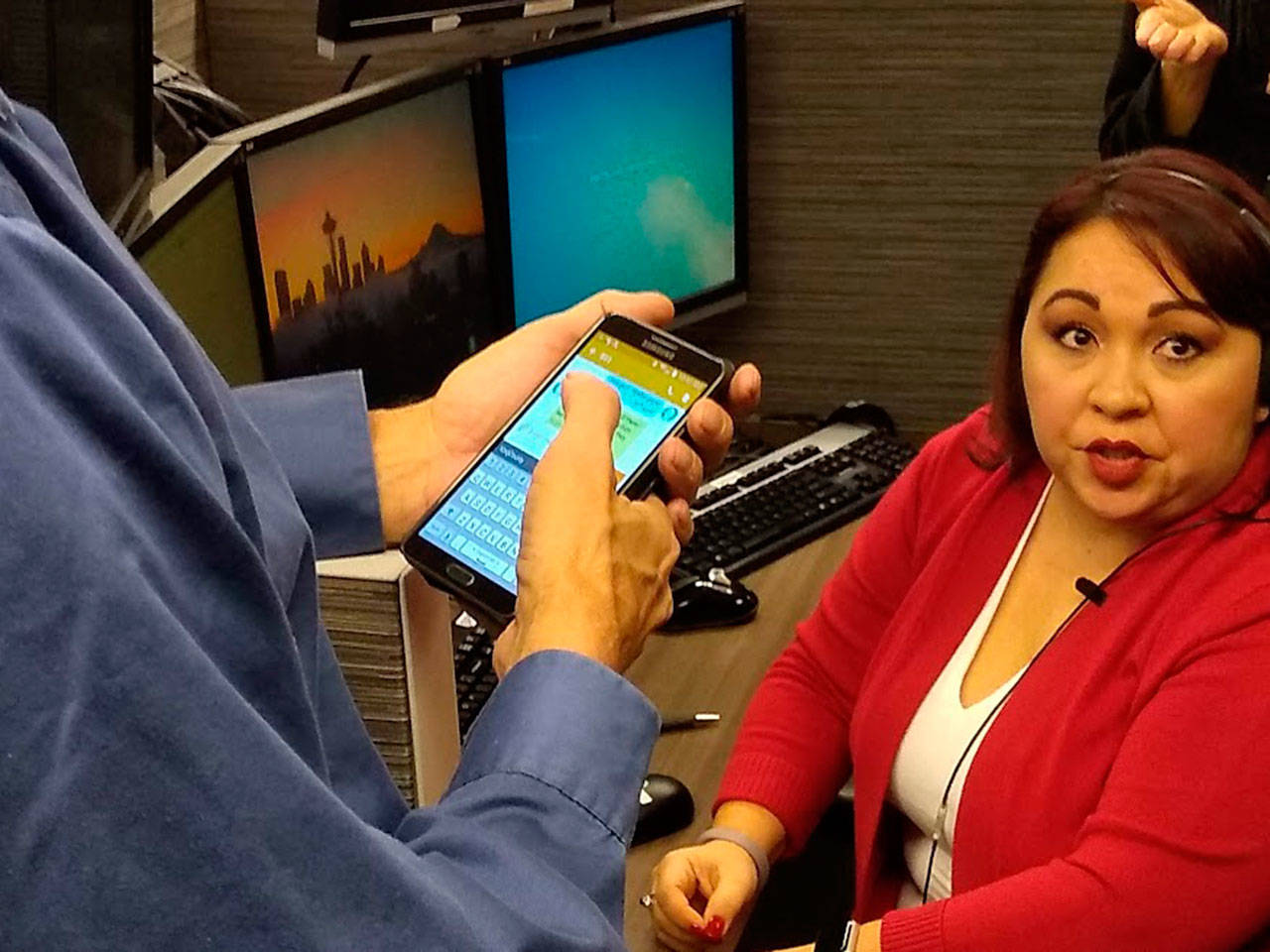 Jim House and Michelle Torresdiaz demonstrate King County’s new Text to 911 service on Dec. 20. Aaron Kunkler/staff photo