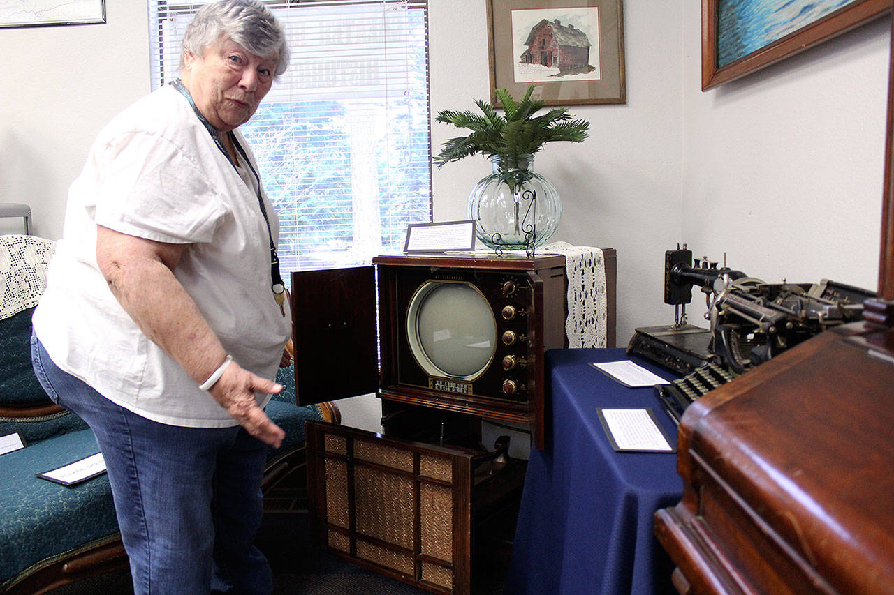 Former Greater Bonney Lake Historical Society President JoAnn Taylor shows off the society’s 1950s Westinghouse TV Combination, which is a TV, radio, phonograph, and record player, all in one entertainment system. Photo by Ray Miller-Still