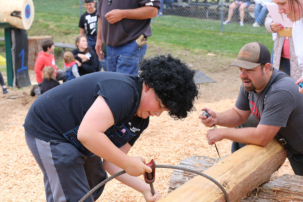 Jack Robbins finishes his try at the choke setter competition during last weekend’s Junior Log Show. Below, Alle Klemkow takes a moment to pose during the ax toss, and Skylar Haulet competes in the rope climb. Photos courtesy Ashley Britschgi.