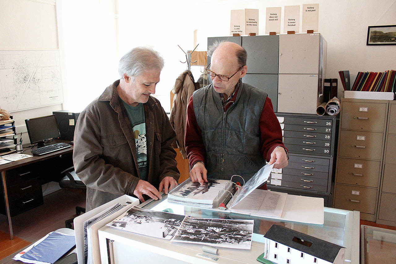 John Sheridan looks at some of Enumclaw’s historical photos with Enumclaw History Museum docent Reid Peterson for his puzzle program idea with the Enumclaw library. Photo by Ray Miller-Still