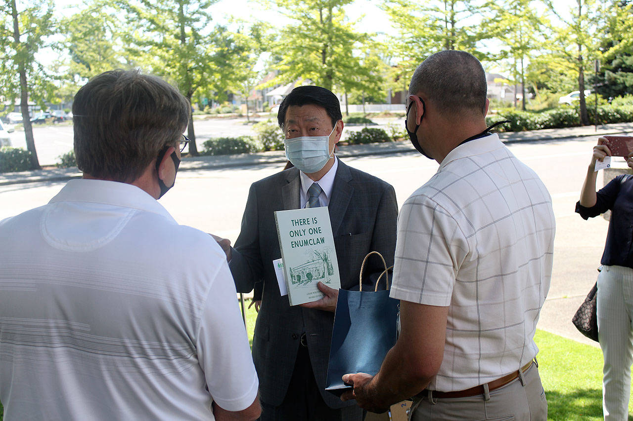 In addition to King County giving Enumclaw thousands of masks, the city also received a donation of masks from the Seattle-based Taipei Cultural Economic Office, headed by Alex Fan, left. “Even though we only donated 1,000 mask to Enumclaw this time, we believe it could open up opportunities for mutual sharing and foster deeper relationship in near future,” said Fan’s secretary, Vicki Shih. According to Fan, Taiwan’s efforts to fight against the COVID-19 pandemic have resulted in less than 500 cases, and deaths have yet to reach double-digits; this is due to the fact that the country was hit hard by a SARS outbreak in 2003, and the country now requires all medical institutions to conduct yearly pandemic training. During a small ceremony outside city hall, Fan and Mayor Jan Molinaro exchanged gifts, which included gifting a copy of the locally-written “There’s Only One Enumclaw,” by Louis Poppleton, to Fan, who lives in Seattle. Photos by Ray Miller-Still