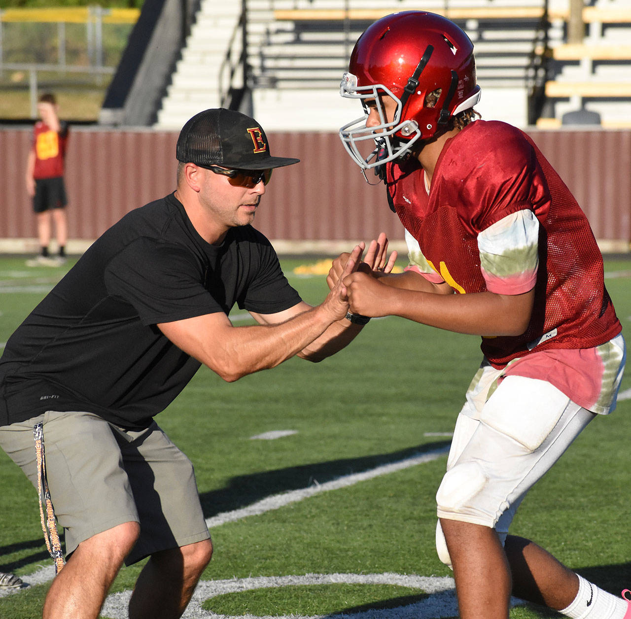 It’s been a while since local schools have been able to practice sports. Pictured is Coach Mark Gunderson working on technique with one of his players during an Aug. 28, 2019 practice. Photo by Kevin Hanson