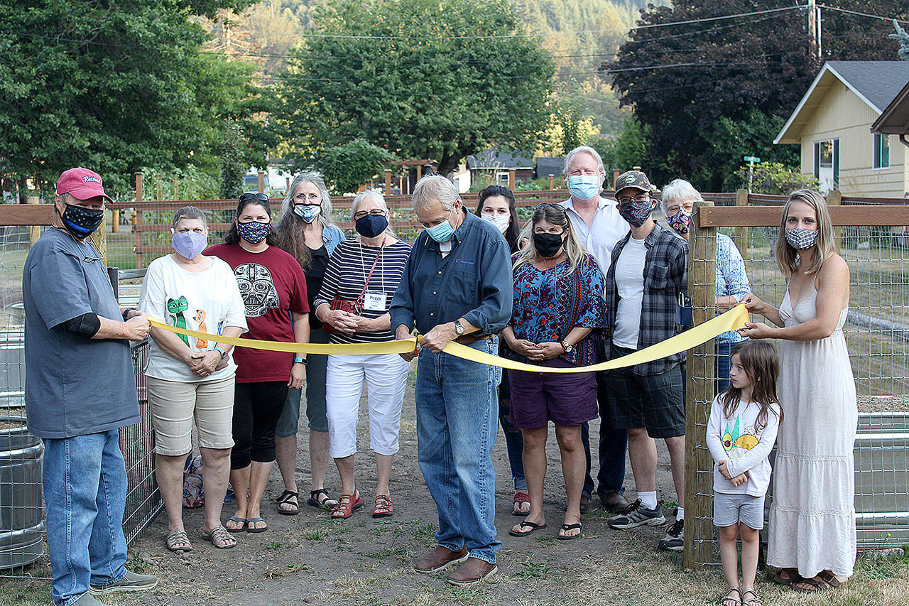 This group of local volunteers got together in September 2019 as a part of a Rural Development Initiative program that aimed to help locals develop leadership skills before sending them off to perform their own community project with a small budget. Pictured is Rick Sellers, Ramsey Graham, Lacey Mansanarez, Sue Hart, Peggy Levesque, Mayor Jeff Sellers, Alli Brewer, Leah Haugen, Trip Hart, David McArtor, Jan Burley, Deyton Cunningham, and Venise Cummingham as they cut the ribbon on a community garden in Wilkeson when the project finished summer of 2020. Photo by Ray Miller-Still