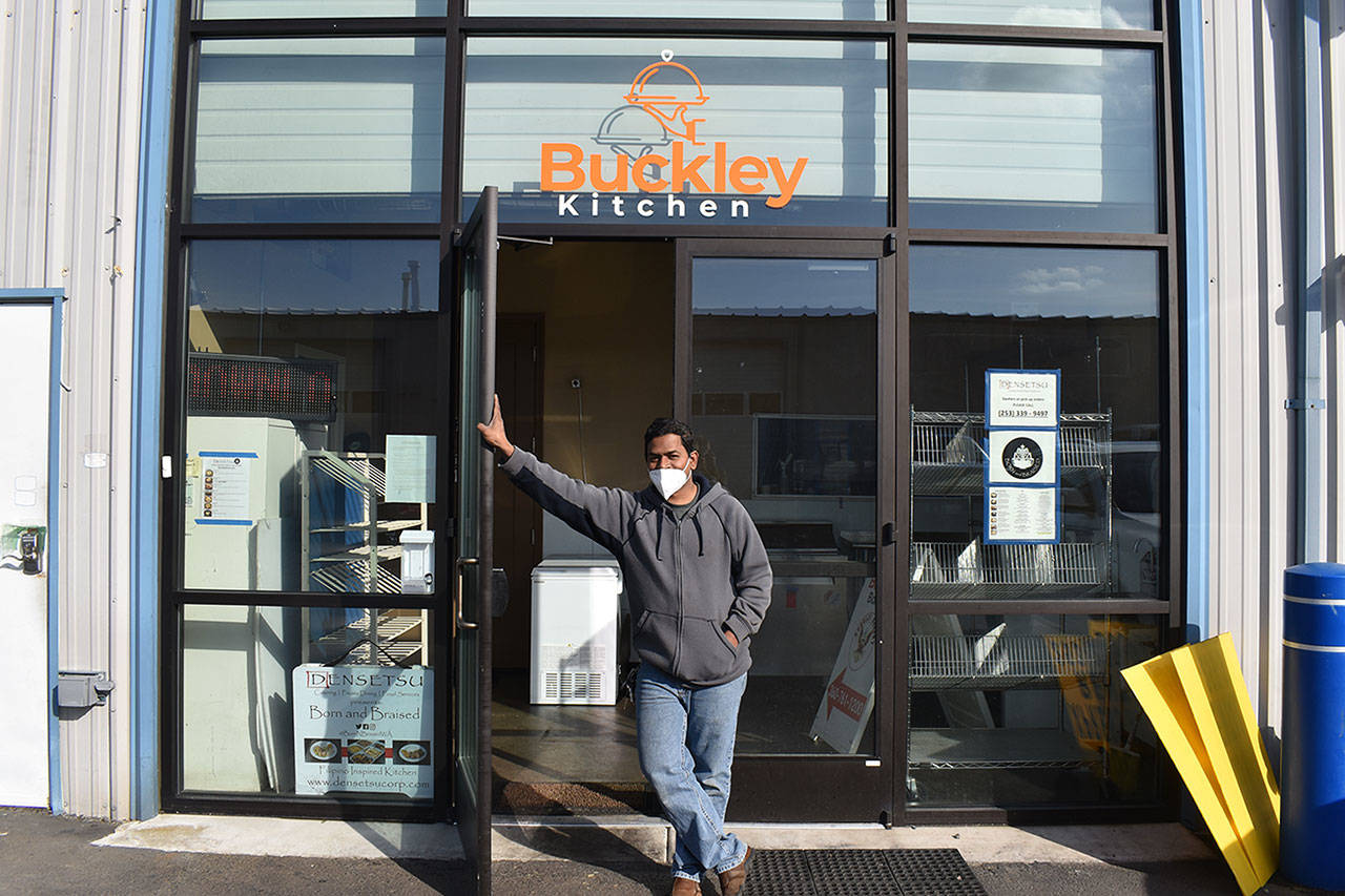 Teago Manoharan on March 16 holds open the door to the Buckley Kitchen, a commissary kitchen he started in 2019 that hosts a number of bakers and chefs who couldn’t otherwise afford a space to cook. Photo by Alex Bruell