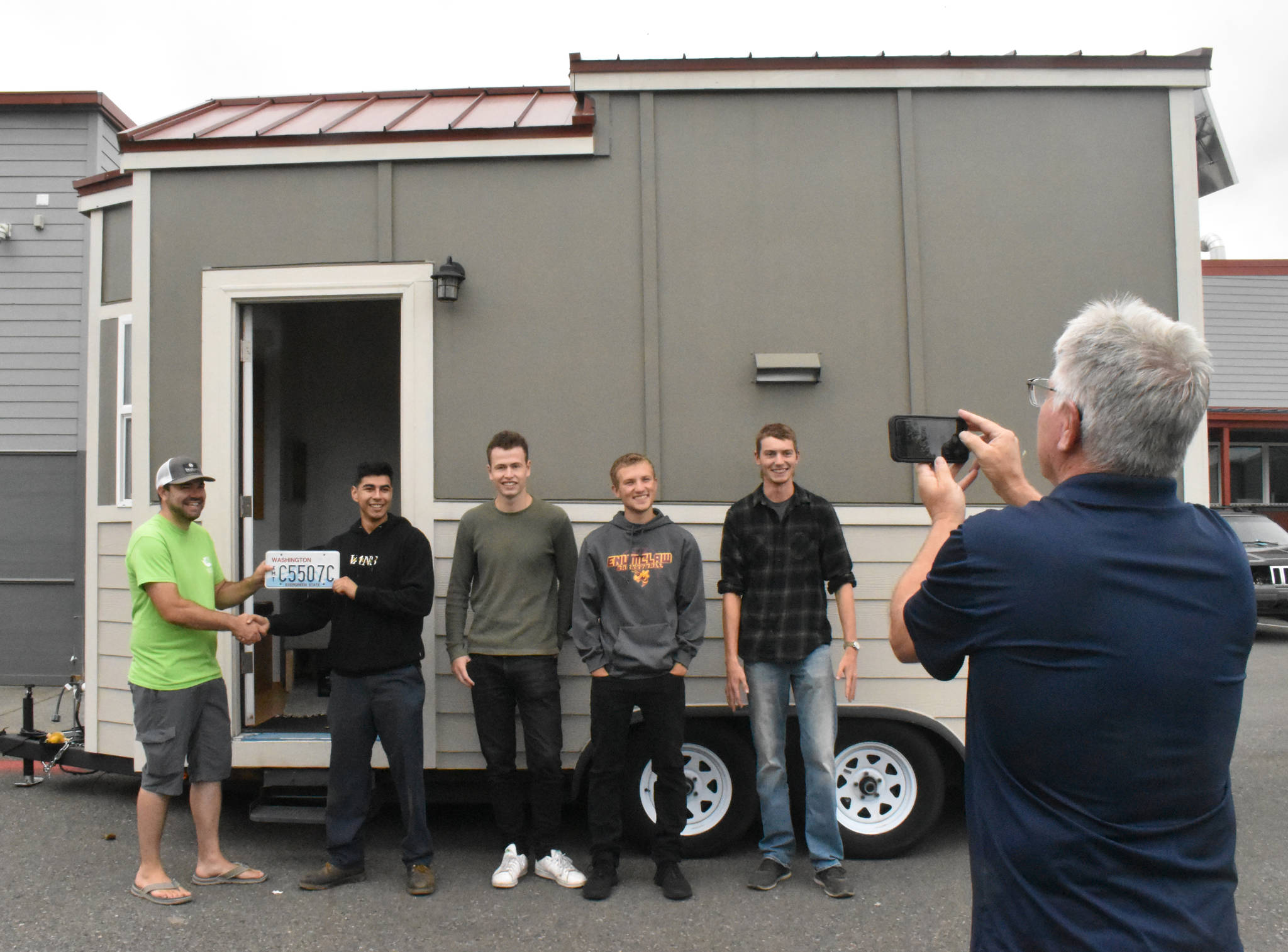 PHOTO BY KEVIN HANSON
Former EHS teacher Bob Kilmer snaps a photo of the tiny house his students created. The home will now used by those advocating for small-home living. Some of the students involved in the project gathered Friday with Todd McKellips (left), director of the Washington Tiny House Association.