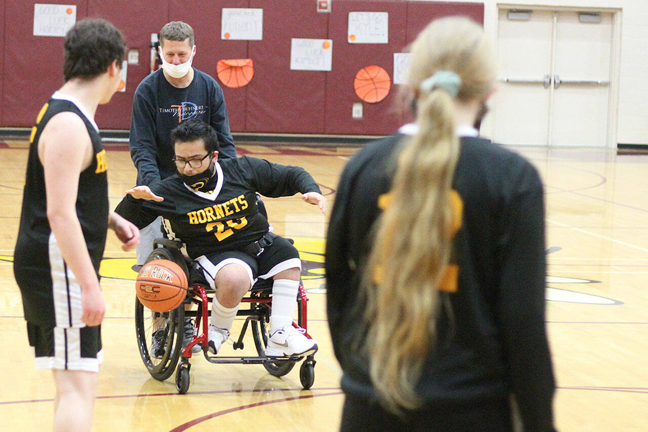 Rafael Jimenez (20) dribbles down the court with the help of local photographer Tim Dehnert. Photo by Ray Miller-Still