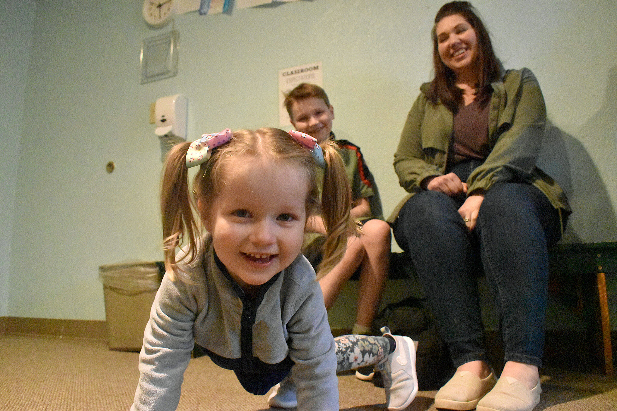 PHOTO BY ALEX BRUELL Isla Pringle, 2, is a bundle of energy at the Wabash Church while her brother Francis and mother Anna sit for a photo behind her.