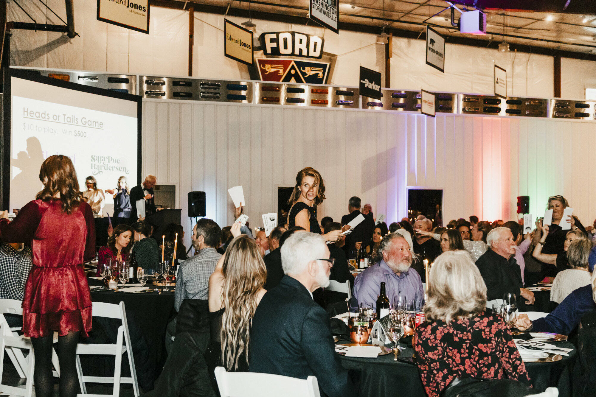 Photo by Lauren Lilly / laurenlillyphotography.com
Pictured is Rainier Foothills Wellness Foundation’s Executive Director Sara Stratton collecting “Heads or Tails” game entry cards during the live auction.