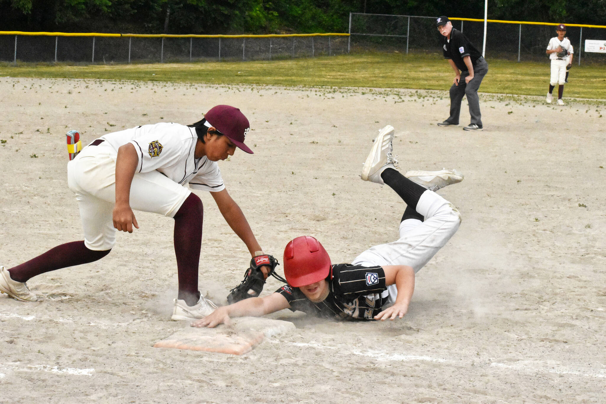 Pictured at the June 13 game is Chinook’s CJ Anderson diving safely back to first base, beating a pickoff attempt. Photo by Kevin Hanson