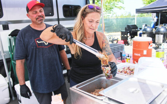 Photos by Ray Miller-Still
Ron Hedin and his boss Julie Ross, who is putting the finishing touches on Hoggin Da Sauce BBQ’s famous Slaw Sundae.