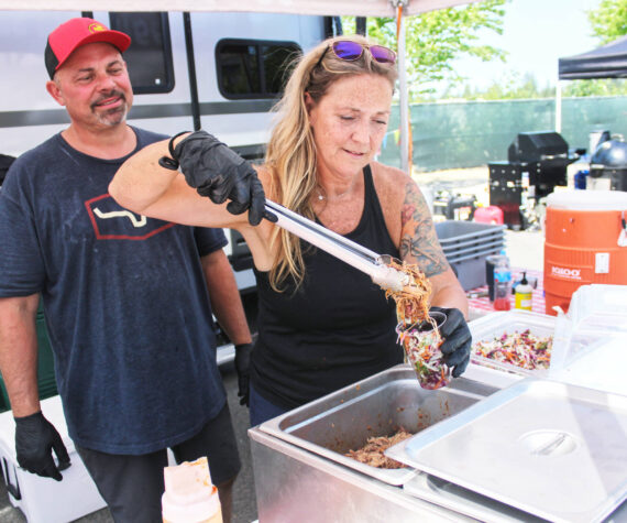 Photos by Ray Miller-Still
Ron Hedin and his boss Julie Ross, who is putting the finishing touches on Hoggin Da Sauce BBQ’s famous Slaw Sundae.