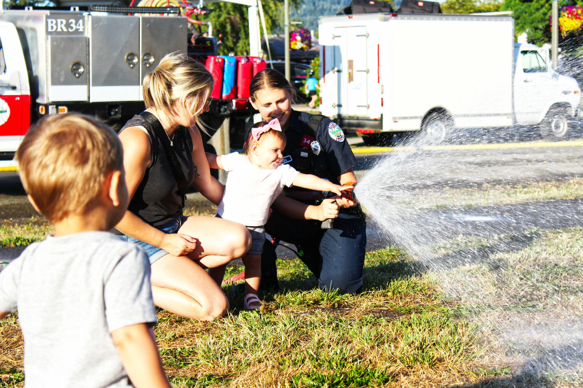 Photo by Ray Miller-Still
Myla Cannizzaro helping a Buckley firefighter with a hose for the splash zone during last year’s National Night Out event.