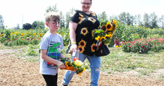 Photos by Ray Miller-Still
Maris Farms’ annual Sunflower Days is over for the season — but there’s always next year! The event boasts five acres of sunflowers and zinnias you can walk through, various local arts vendors, and numerous activities for kids and families. Pictured is Easton Williams and Rachel Mead taking flowers to grandma; Charli and Lilah Hetch on the jumping pillow; and Evie Schutt racing some rubber ducks.