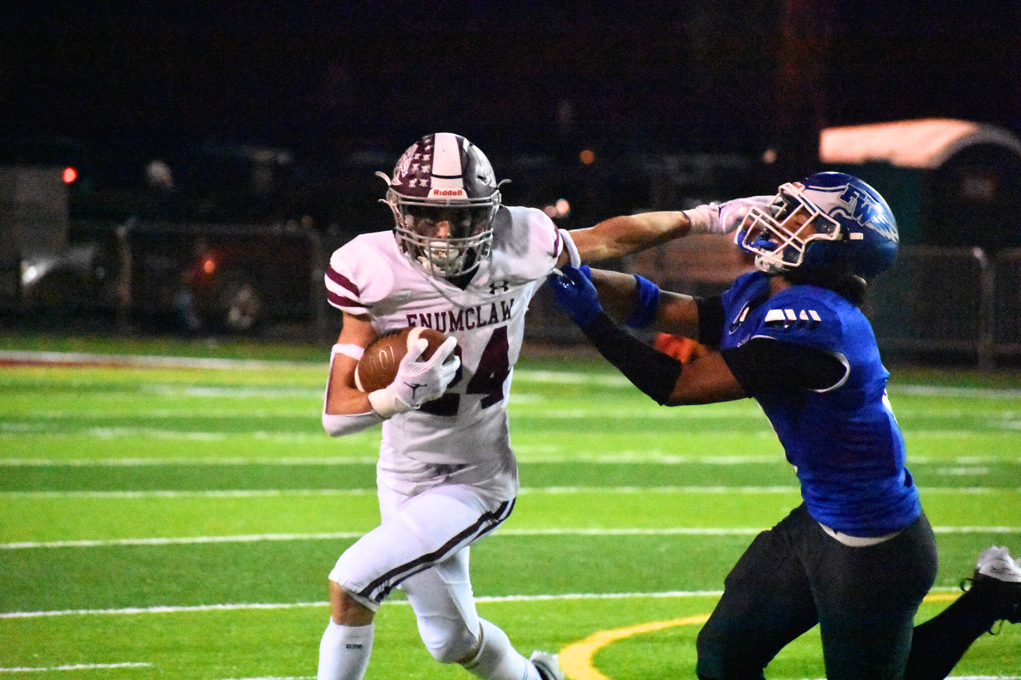 Enumclaw senior RB Louis Chevalier stiff arms an Eagle defender. Ben Ray / The Reporter