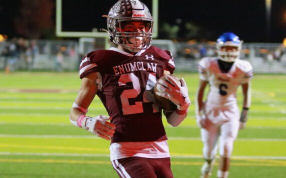 In the reflection of the scoreboard lights No. 24 Louis Chevalier scores another Enumclaw touchdown. Photo by Todd Overdorf / SonScape Images