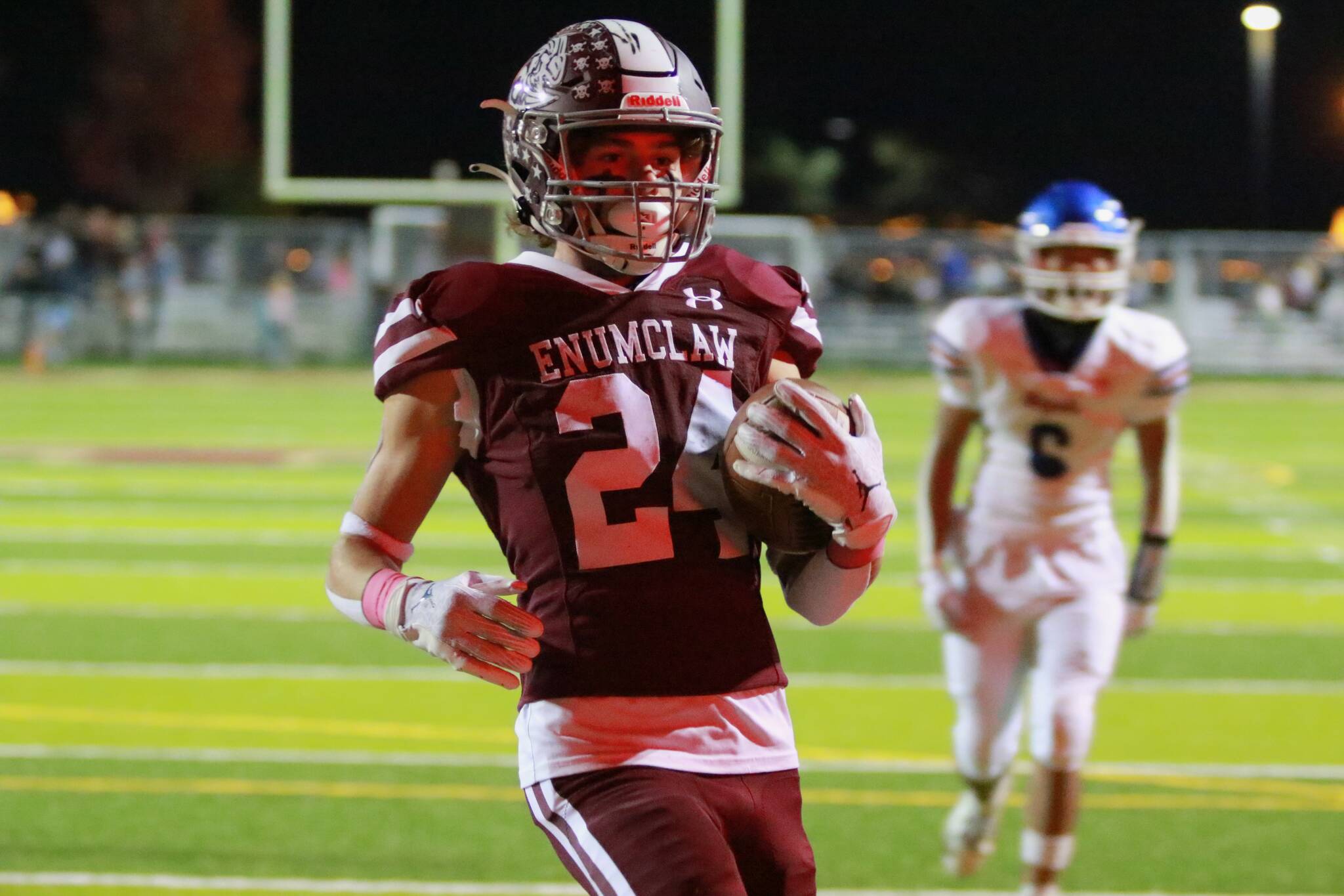 In the reflection of the scoreboard lights No. 24 Louis Chevalier scores another Enumclaw touchdown. Photo by Todd Overdorf / SonScape Images