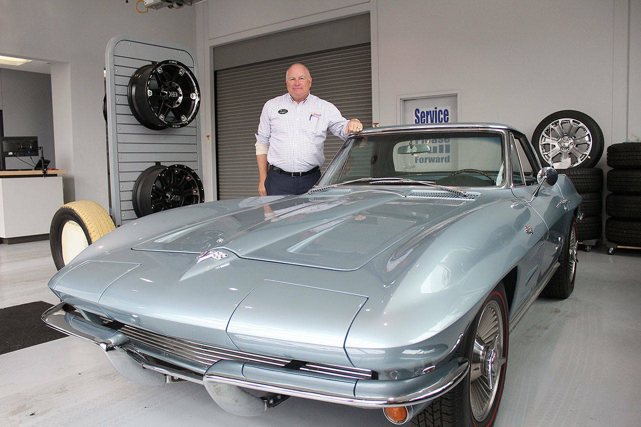 Alan Gamblin, who took over his father’s dealership in 1985, stands in his car shop next to his personal 1964 Corvette in 2019 while celebrating being 50 years in business on the Plateau. Photo by Ray Miller-Still