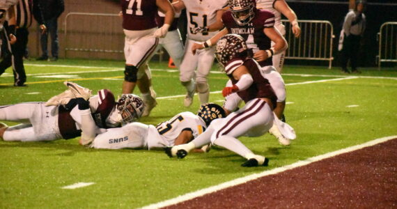 PHOTO BY KEVIN HANSON 
Pictured is a key play in Enumclaw’s Friday night whitewashing of the visiting Southridge Suns. The only time the Suns moved close to the end zone, the Hornets’ Cooper Rodarte wrapped up the legs of the Southridge ballcarrier on fourth down, giving EHS the ball.