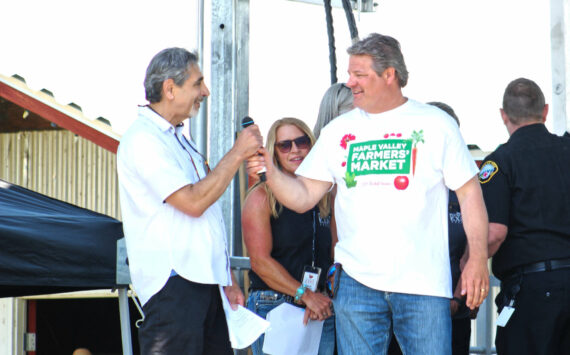 Photo by Ray Miller-Still
King County Councilmember Reagan Dunn often visits Enumclaw for large events like the King County Fair. Here he is receiving the mic from Enumclaw Mayor Jan Molinaro at the fair’s opening ceremony.