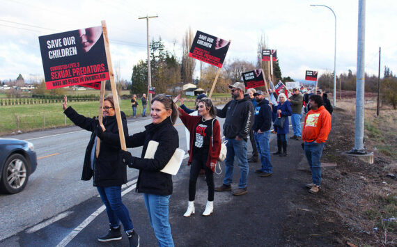 About a hundred people gathered in SR 164 outside Garden House, a group home for high-level sex offenders on Feb. 17, 2023, to protest and gain support to pressure the state to move sole resident Stevan Knapp, including Cathy Dahlquist (at front). Photo by Ray Miller-Still